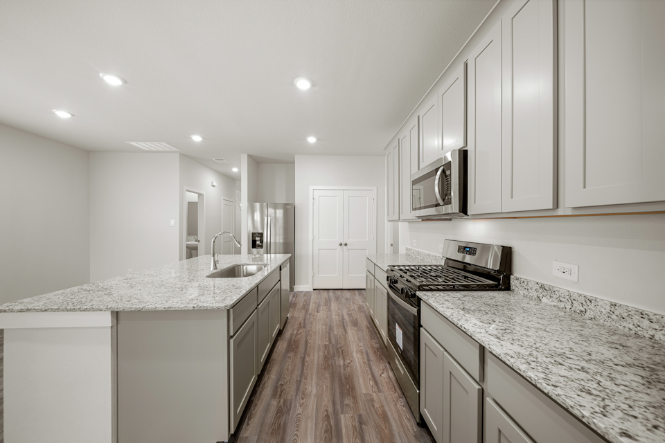 A kitchen with white cabinets.