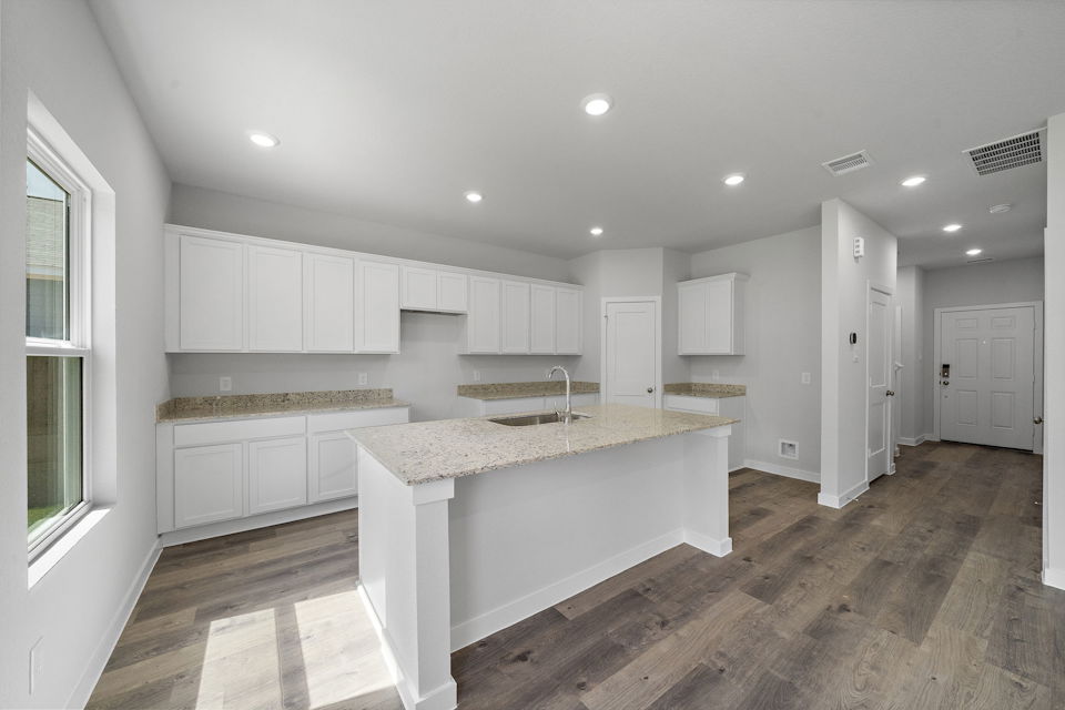 A kitchen with white cabinets.