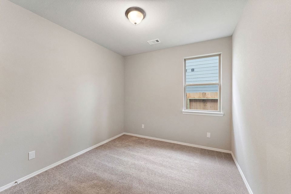 A room with a carpet and a window.