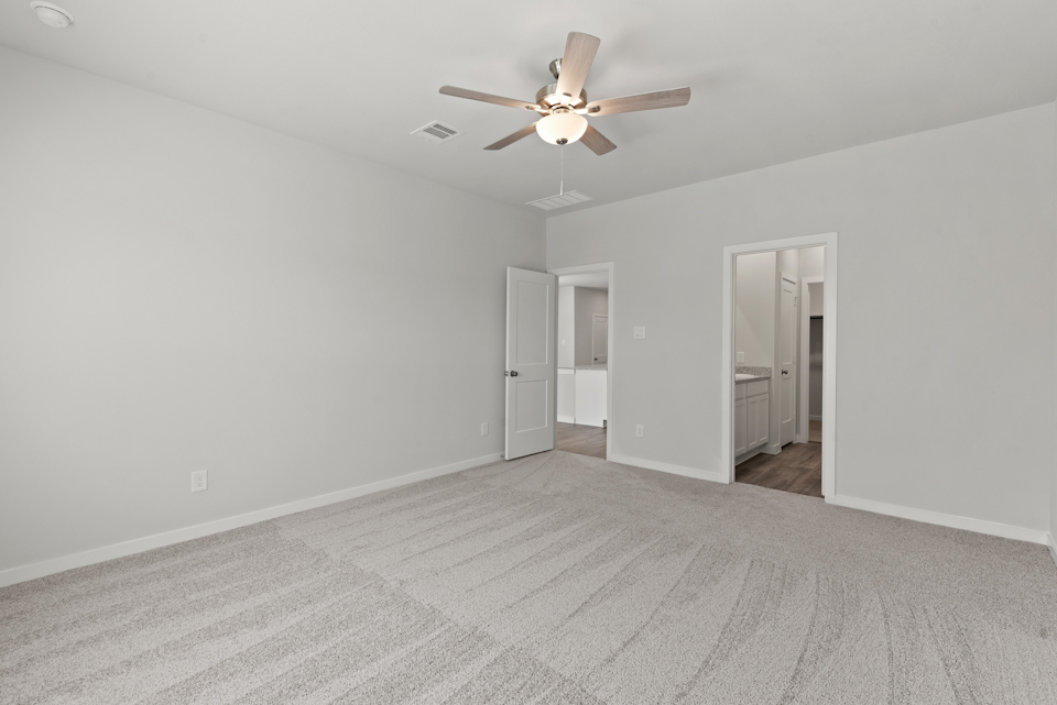 A room with a ceiling fan and a door.