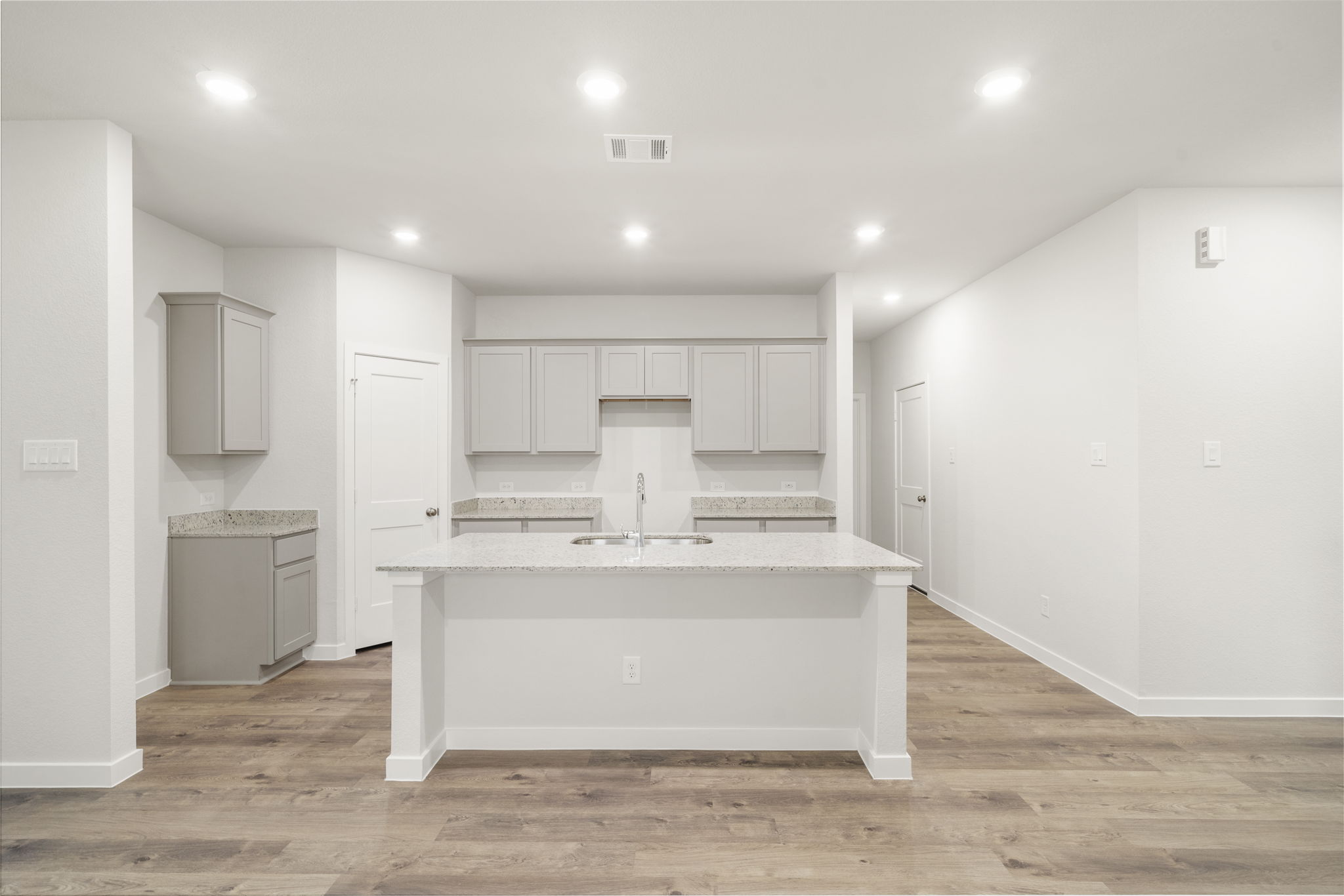 A kitchen with white cabinets.