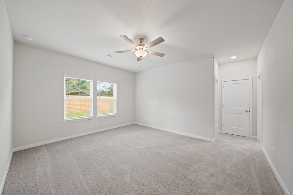 A room with a ceiling fan and a window.