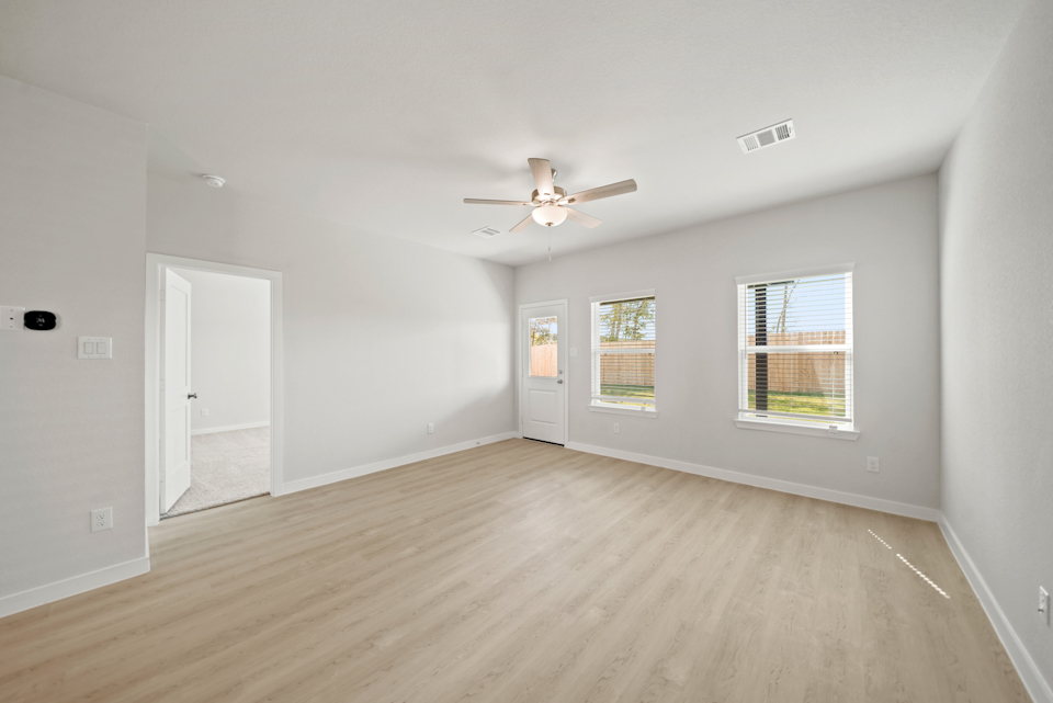 A room with a wood floor and a ceiling fan.