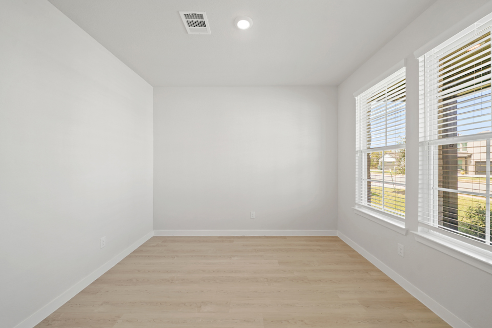 A room with windows and a wood floor.