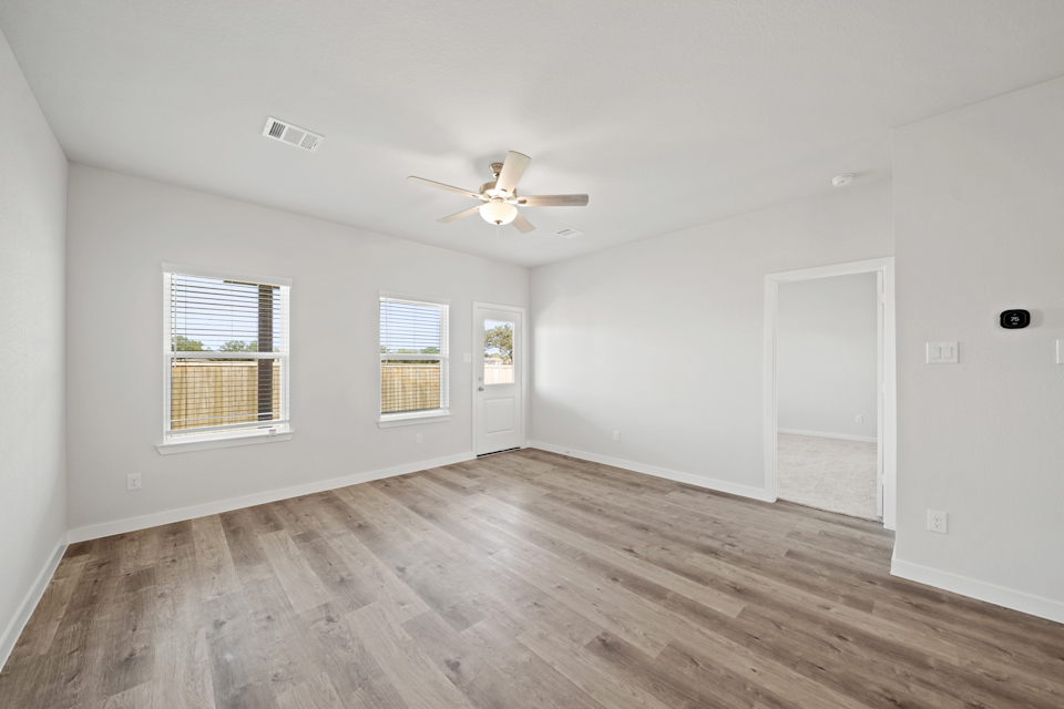 A room with a wood floor and a ceiling fan.