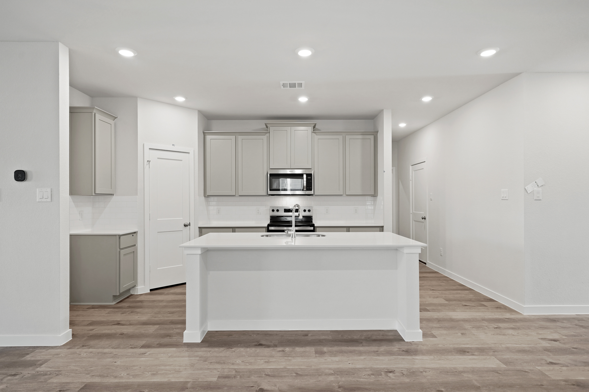 A kitchen with white cabinets.