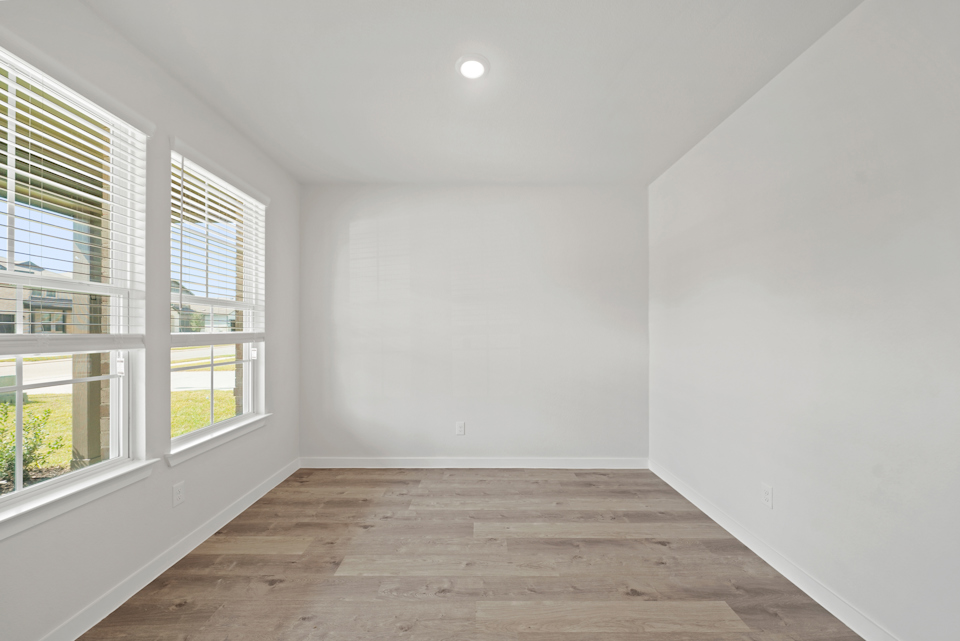 A room with windows and a wood floor.