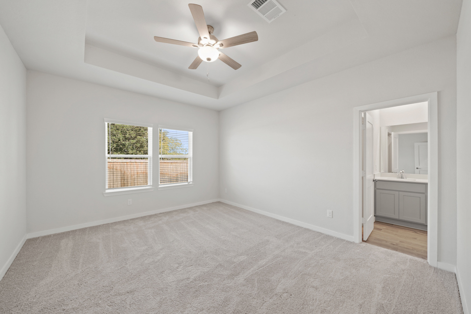 A room with a ceiling fan and a window.