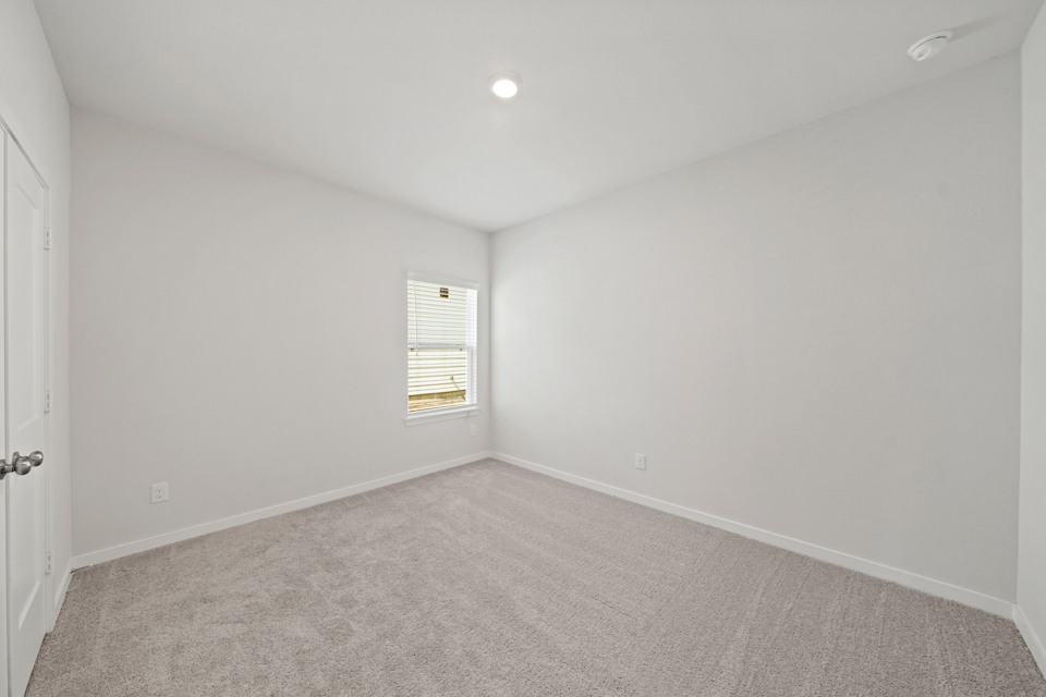 A room with a carpet and a door.