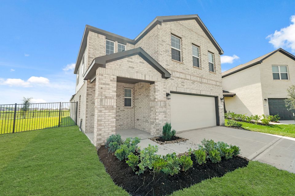 A house with a fence and bushes.
