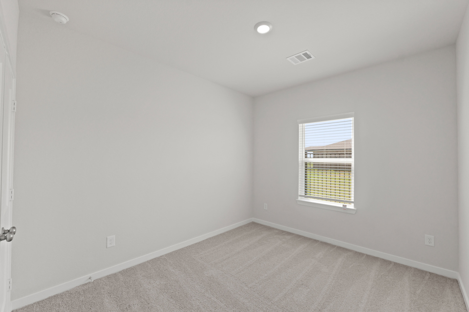 A room with a window and a carpet.