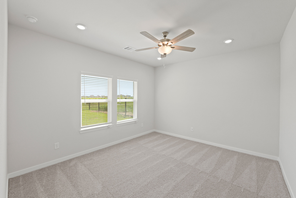 A room with a ceiling fan and a window.