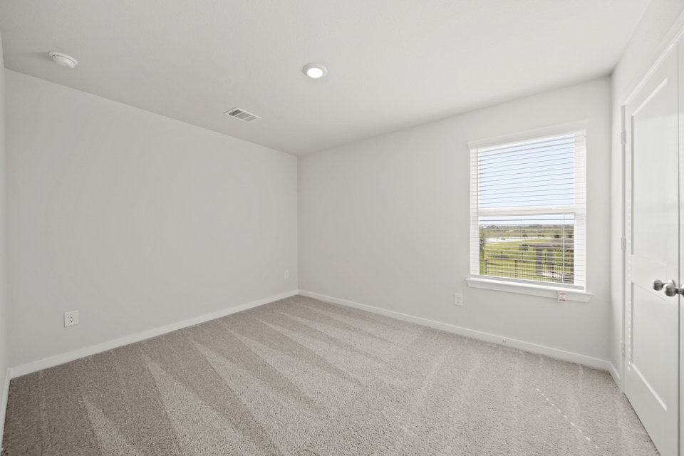 A room with a window and a carpet.