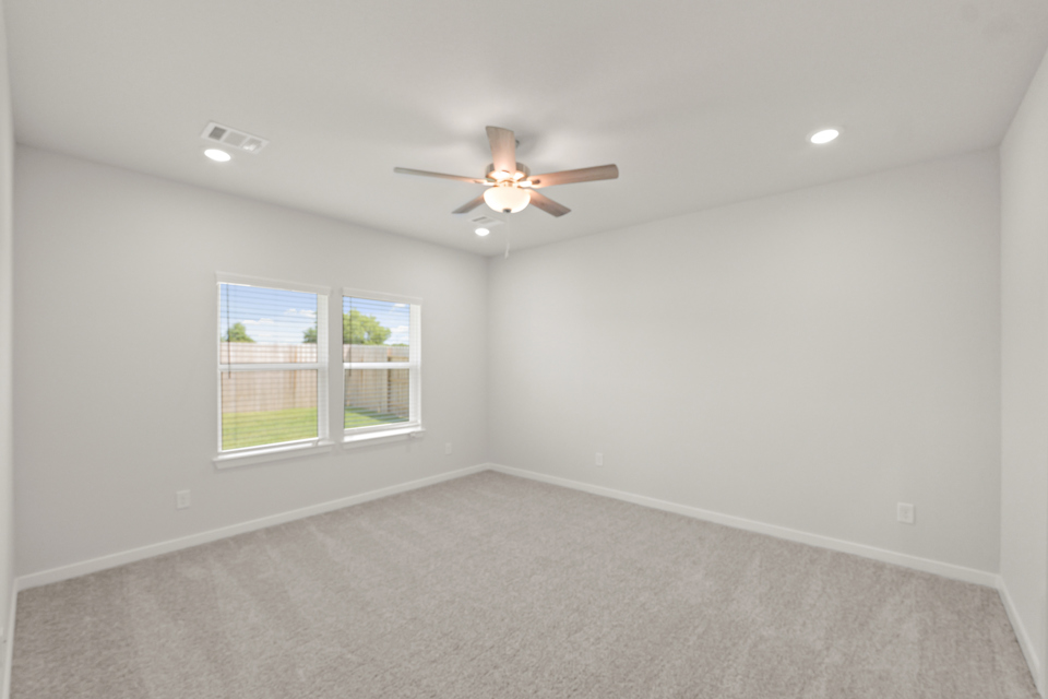 A room with a ceiling fan and a window.