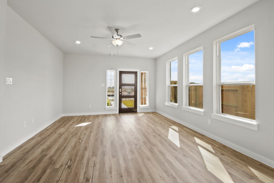 A room with a wood floor and a ceiling fan.