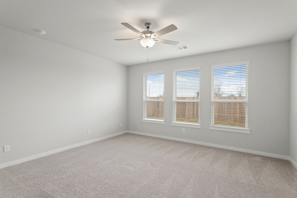 A room with a ceiling fan and a window.