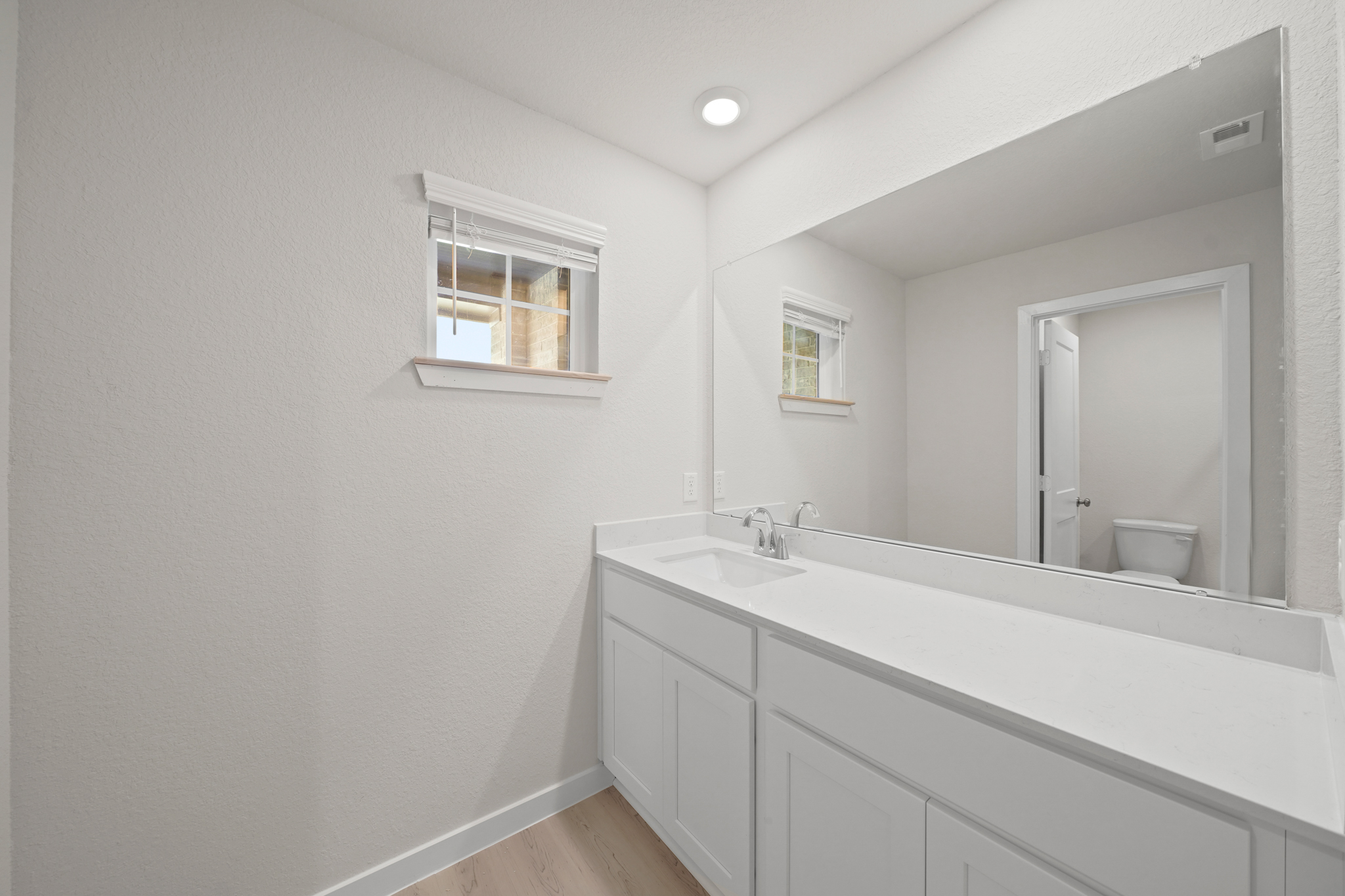 A bathroom with a large mirror.