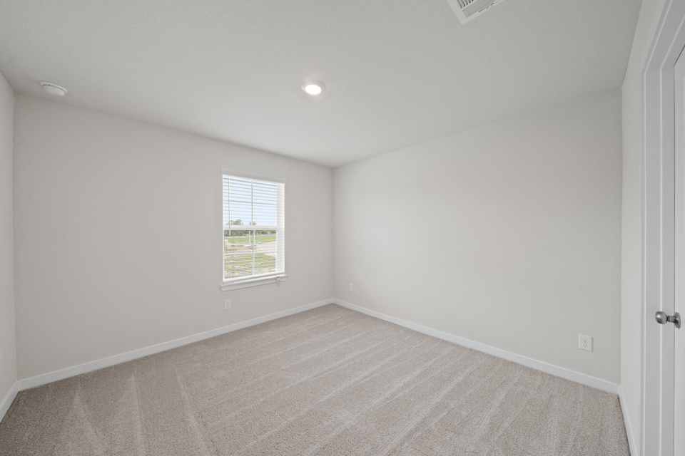 A room with a window and a carpet.