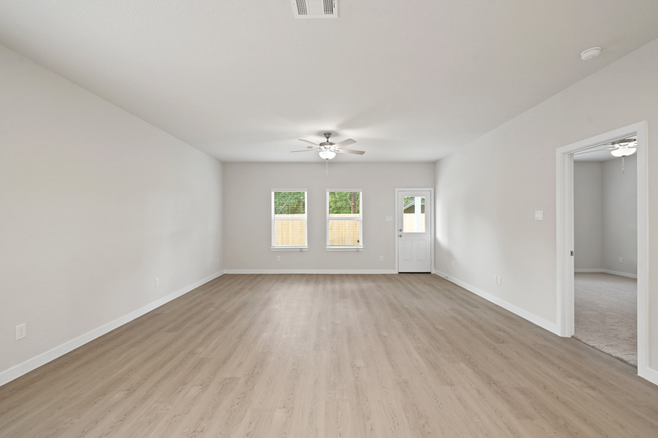 A room with a wood floor and a ceiling fan.