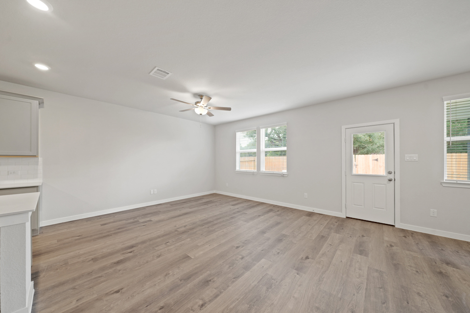 A room with a wood floor and a ceiling fan.