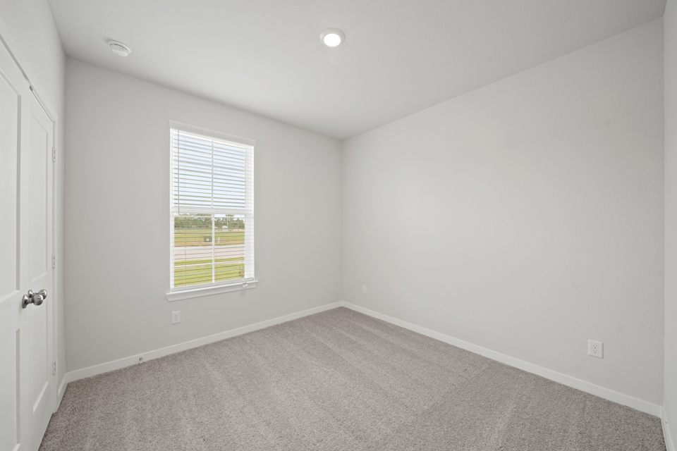 A room with a window and a carpet.