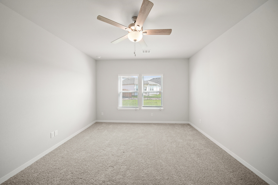 A room with a ceiling fan and a window.