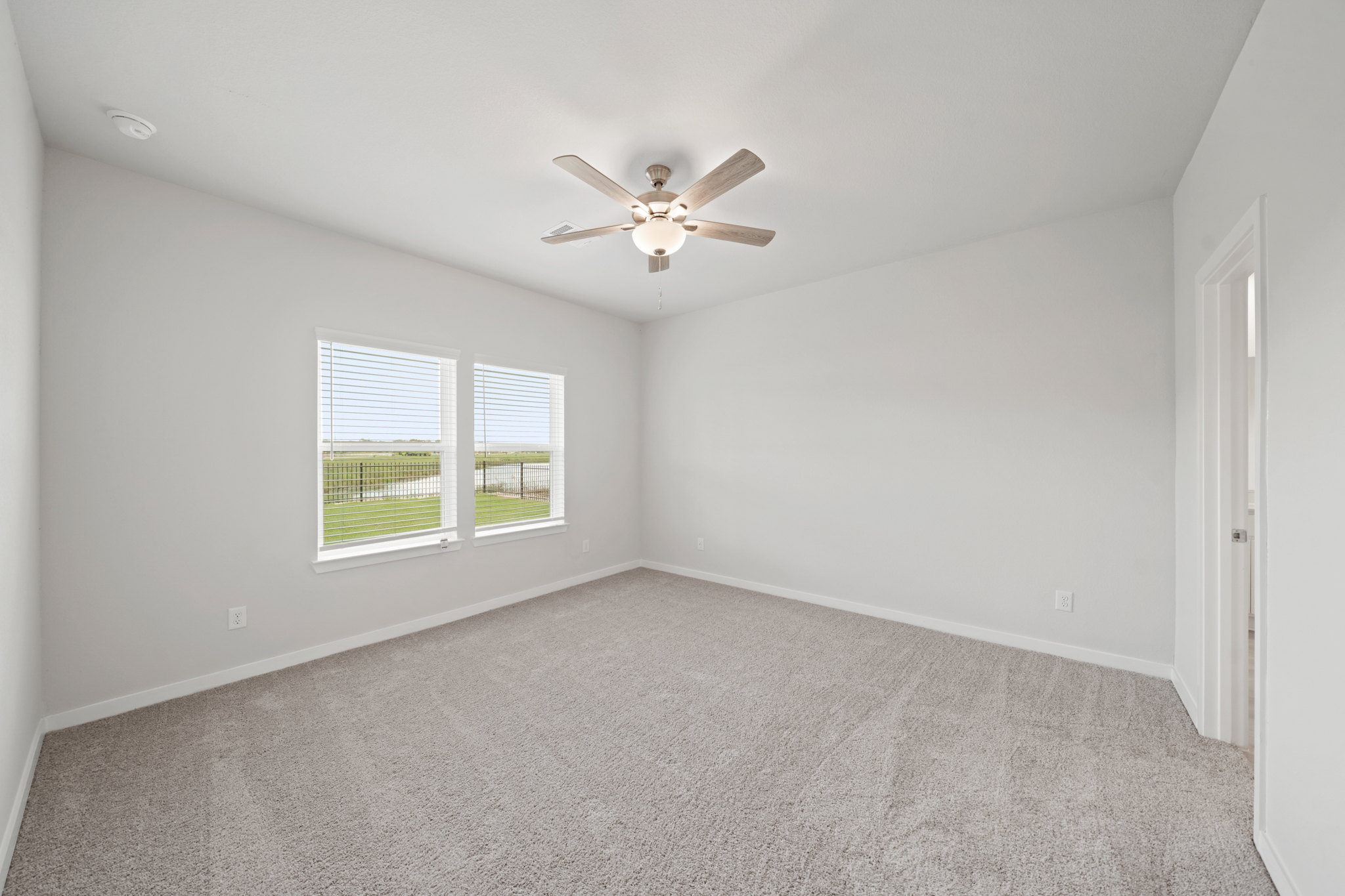 A room with a ceiling fan and a window.