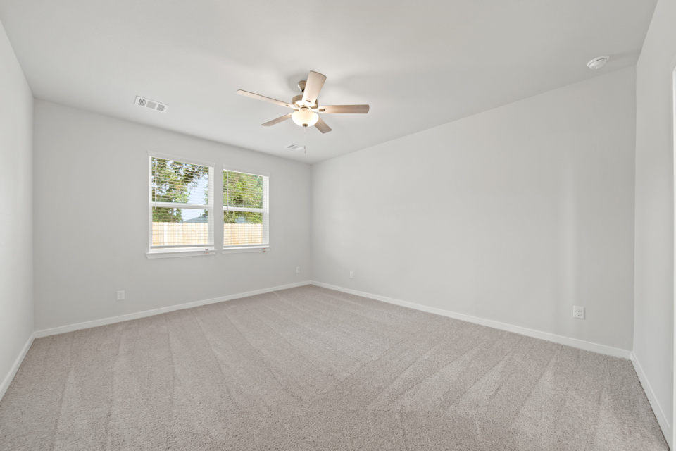 A room with a ceiling fan and a window.
