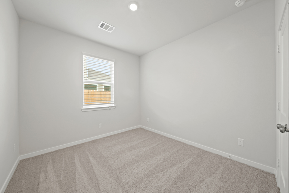 A room with a carpet and a window.