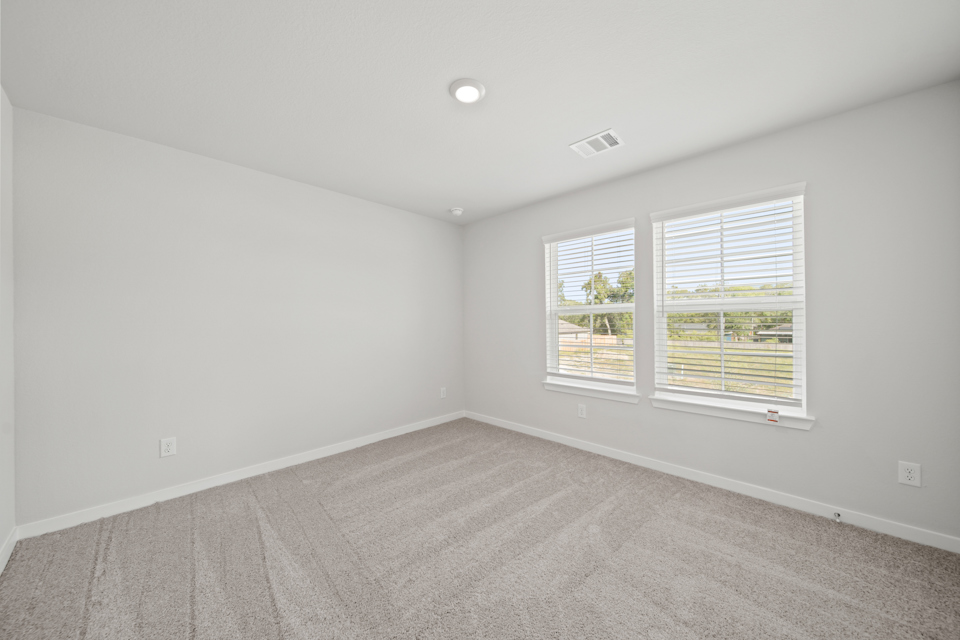 A room with a window and a carpet.