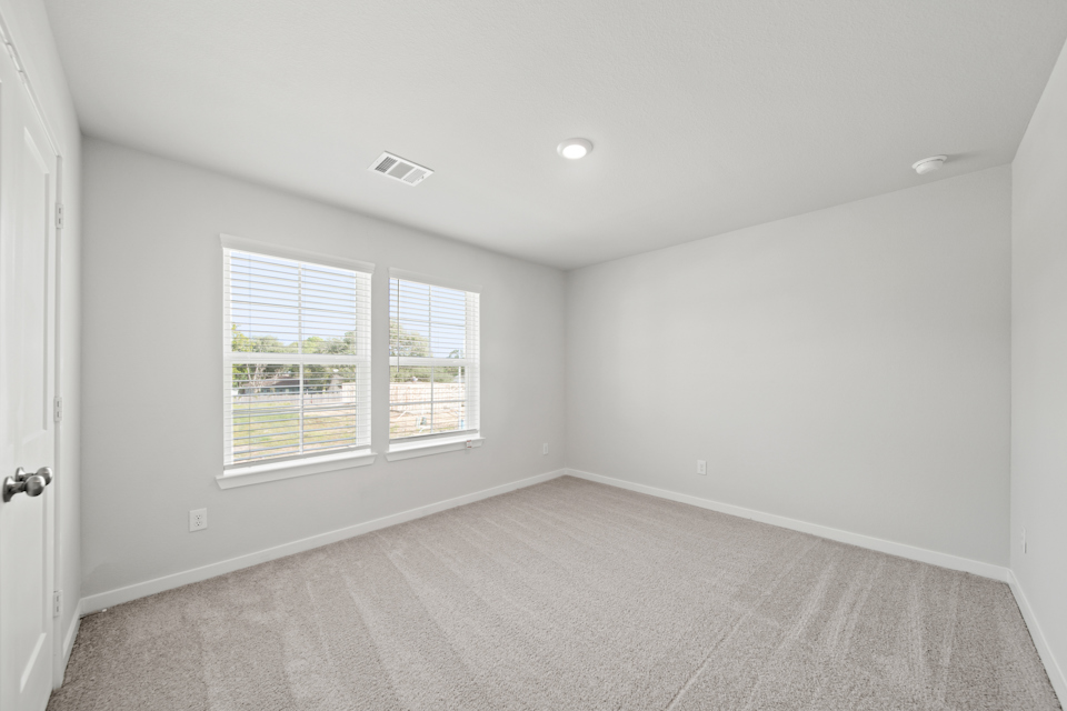 A room with a carpet and windows.