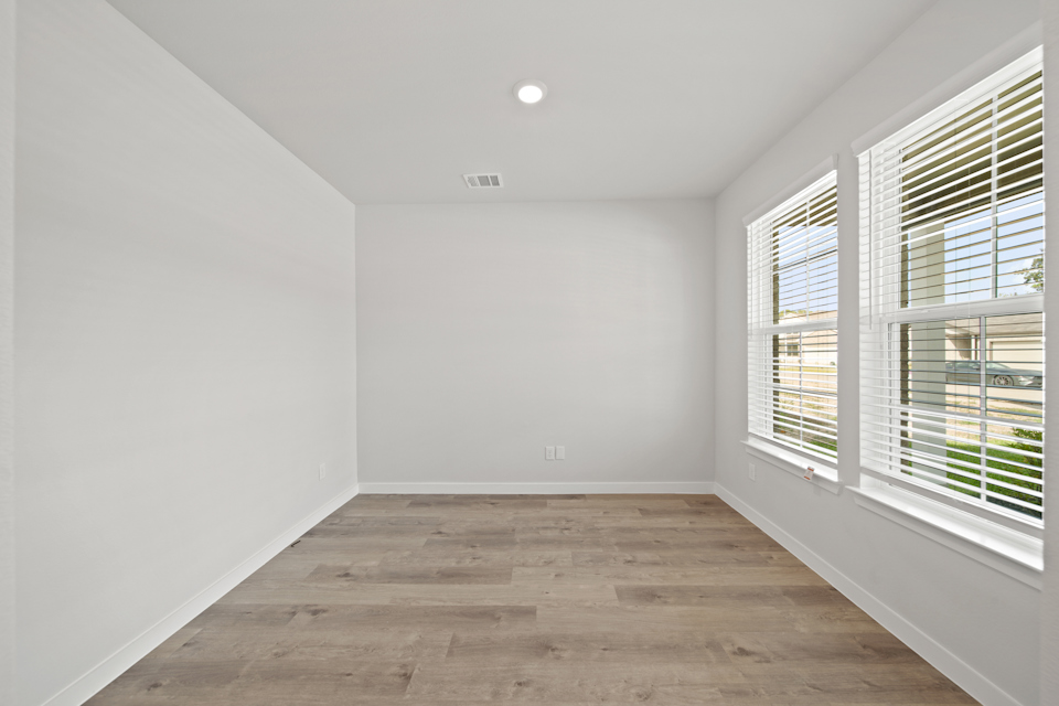 A room with windows and wood floors.