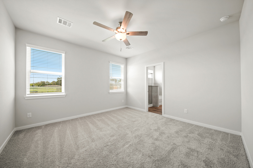 A room with a ceiling fan and a window.