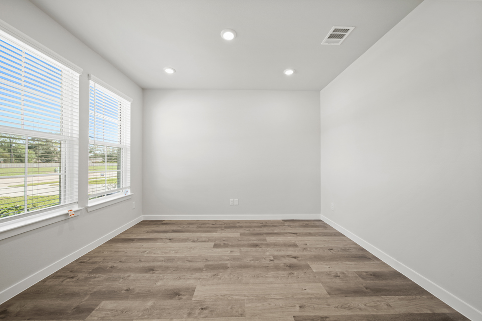 A room with windows and wood floor.