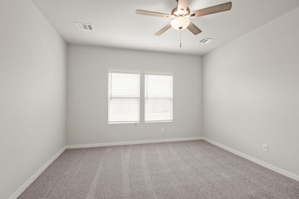 A room with a ceiling fan and a window.