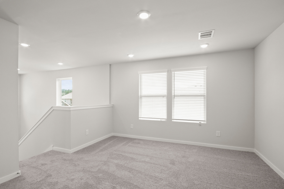 A room with a white wall and windows.