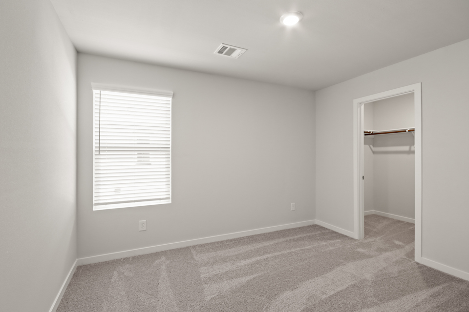 A room with a carpet and a window.
