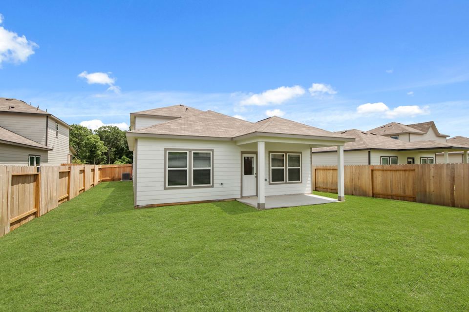 A house with a fence and grass.