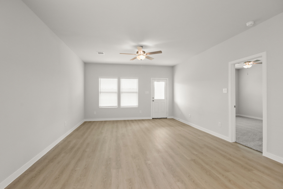 A room with a wood floor and a ceiling fan.