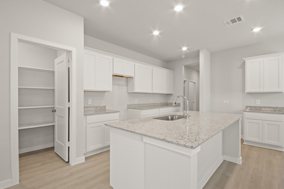 A kitchen with white cabinets.