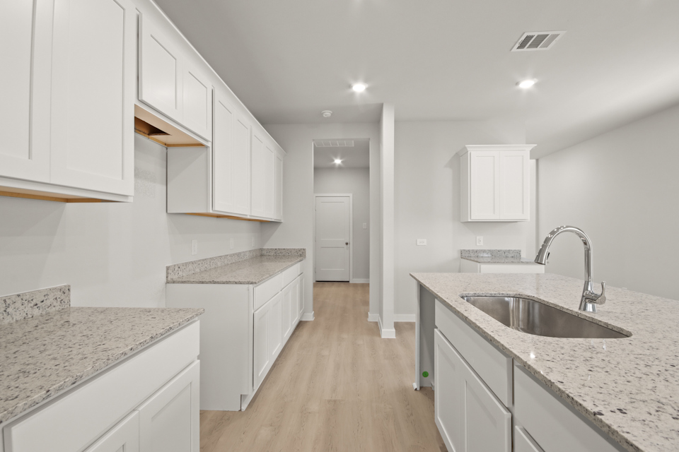 A kitchen with white cabinets.