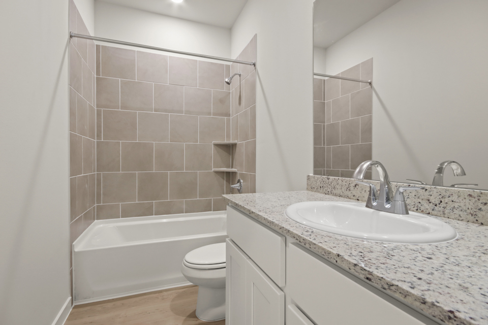 A bathroom with a sink toilet and bathtub.