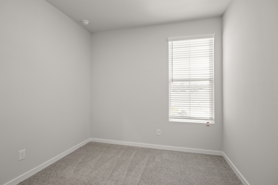 A room with a window and a carpet.