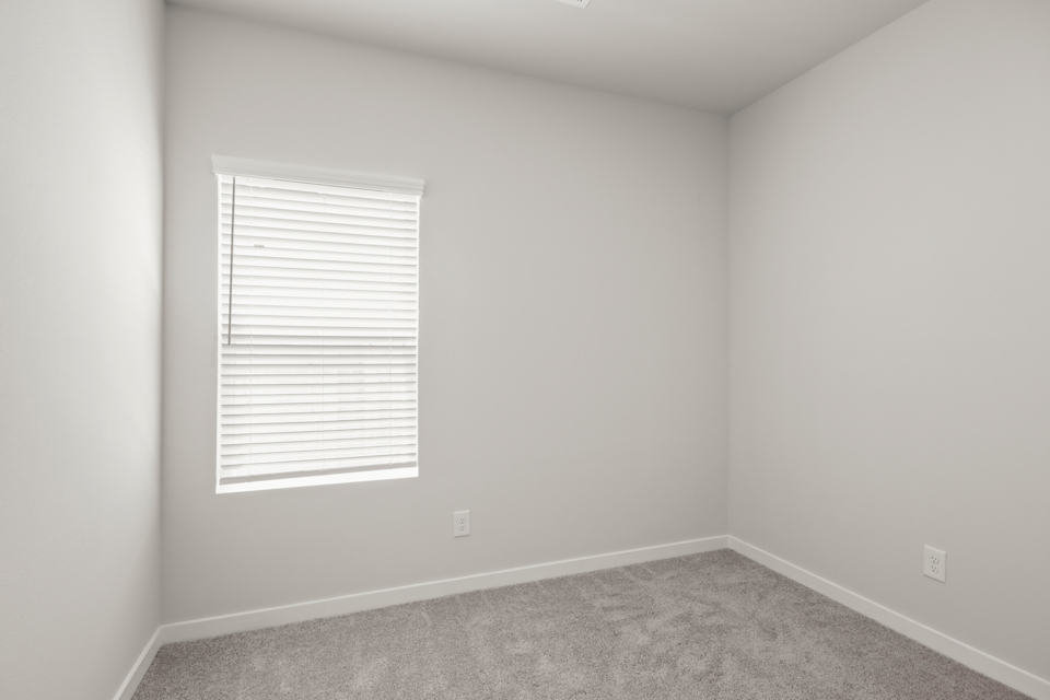 A room with a window and a carpet.