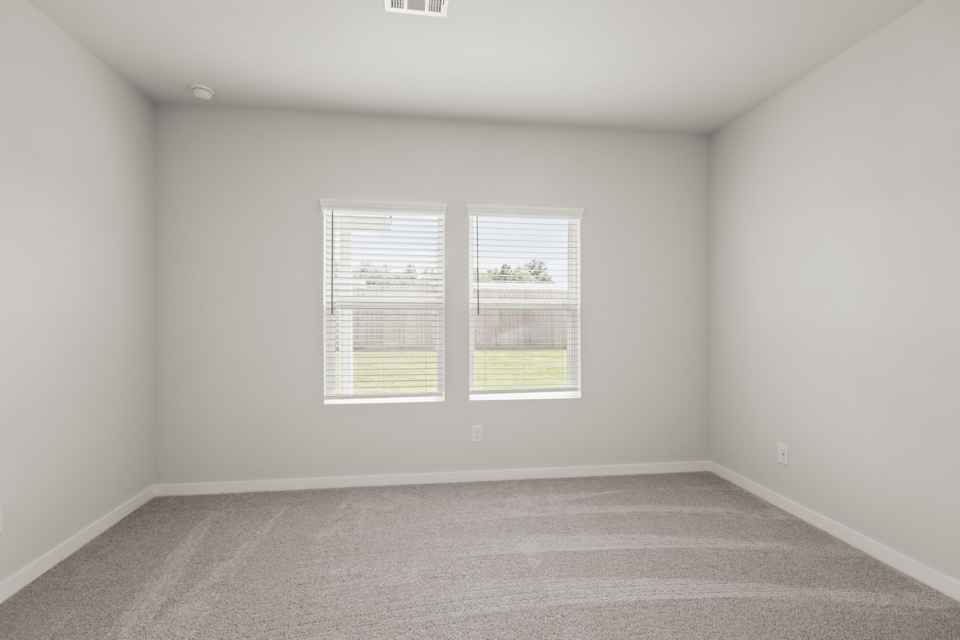 A room with a window and a carpet.