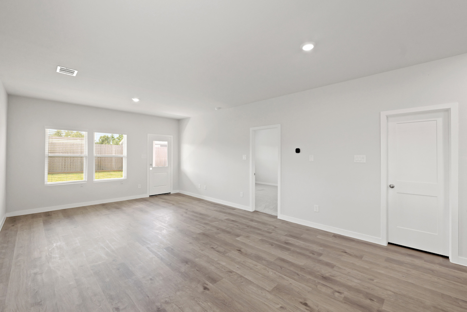 A room with white walls and wood floors.
