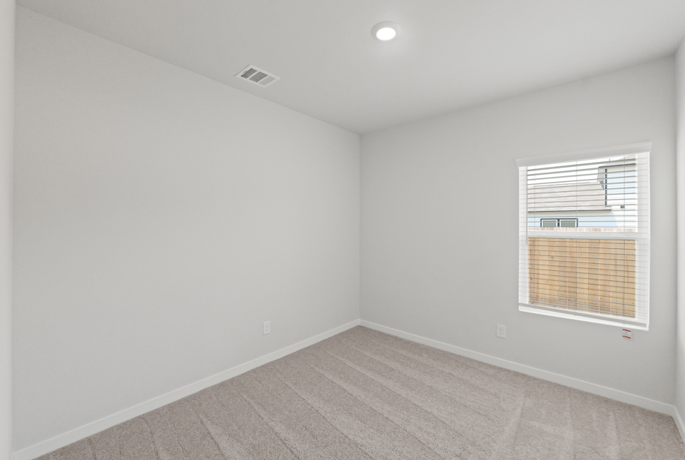 A room with a window and a rug.