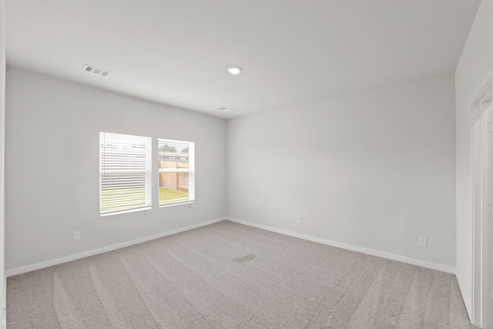 A room with a carpet and a window.