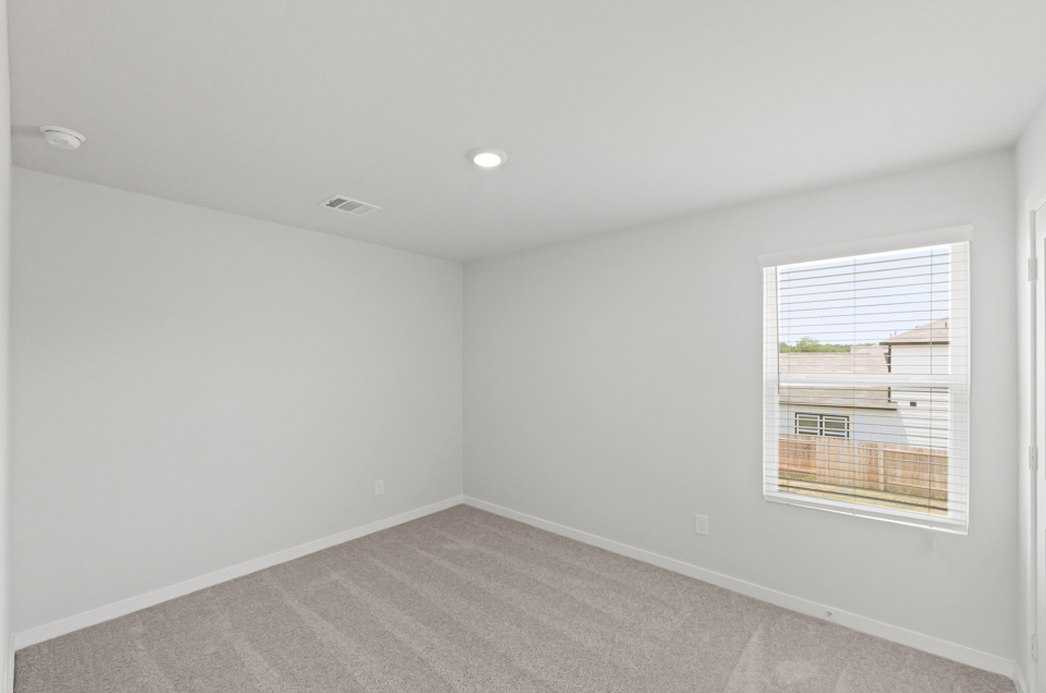 A room with a window and a carpet.