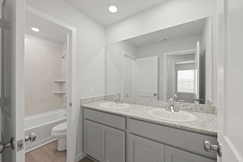 A bathroom with a large mirror.